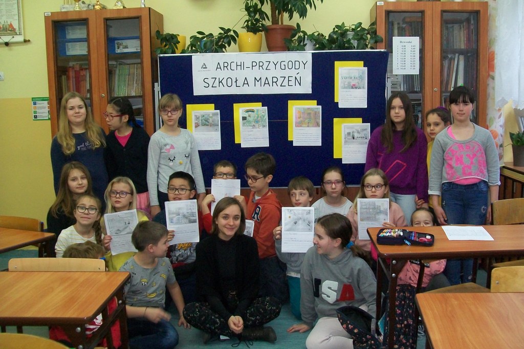 Klasa 5d na tle tablicy prezentującej prace na temat Szkoły marzeń