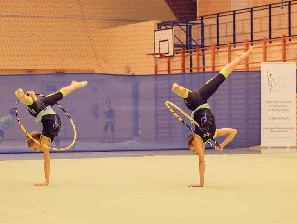 Dwie gimnastyczki ćwiczące z obręczami.