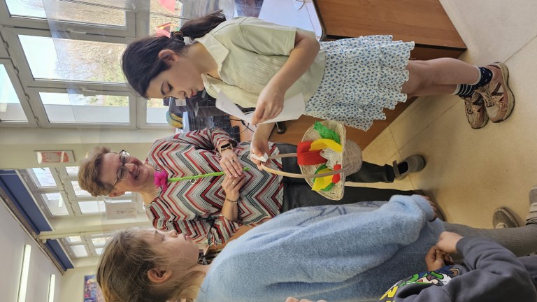 Pani Wiosna i pani bibliotekarka zachęcają uczniów do wzięcia udziału w wiosennej zabawie.